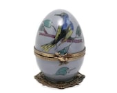 Gray musical egg decorated with exotic bird and tabby cat. Customizable object original decorative gift. French art crafts