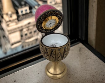 Horloge rouge porcelaine Limoges, telle une horloge immuable, égrène le temps avec élégance, symbole de finesse dans l'éternité du quotidien