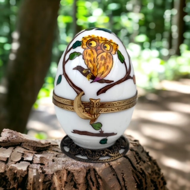 Une chouette délicate orne un oeuf musical, une porcelaine de Limoges renfermant un hibou min
