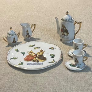 Servizio da tè in miniatura da 10 pezzi in porcellana dorata con Peter Rabbit e Benjamin Bunny di Beatrix Potter.