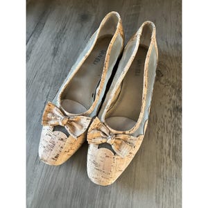 Puede incluir: Par de zapatos planos de la marca Van Eli. Los zapatos tienen un material similar al corcho en la puntera y una parte superior de malla transparente. Cada zapato tiene un lazo en la puntera. Los zapatos son de color neutro.