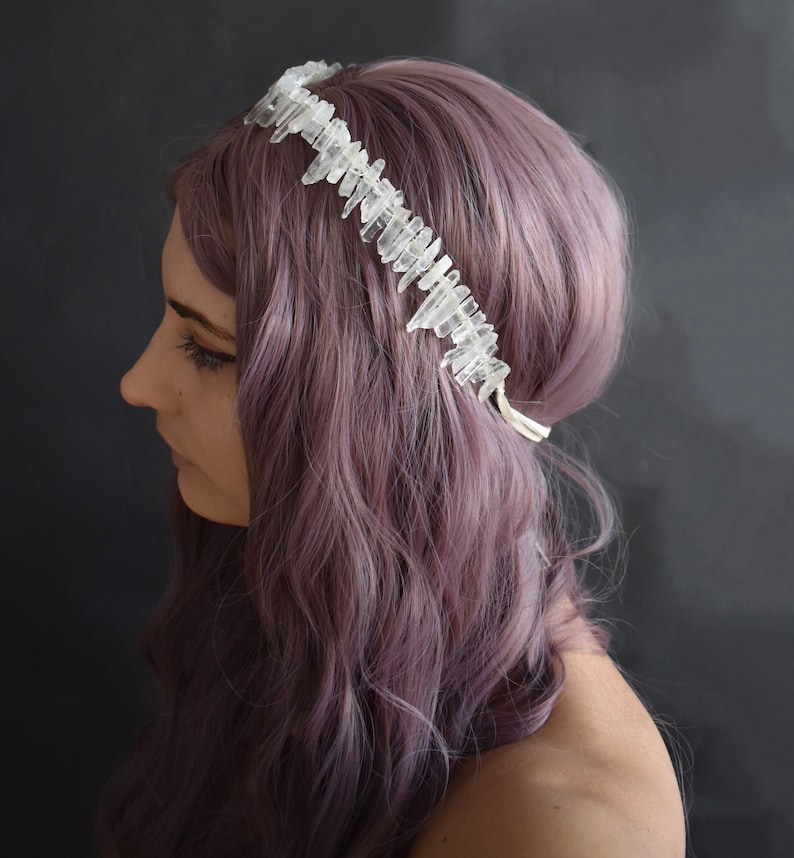 May include: A crystal crown headband with clear quartz points, worn by a person with purple hair.