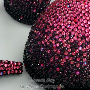 May include: A black and pink ombre bra with rhinestones. The bra is decorated with a gradient of pink rhinestones that fade to black. The bra is labeled "Amnesia Shop by Alyona Konstantynova".
