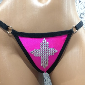 May include: Pink and black lingerie with a rhinestone cross design.