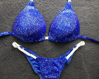 Puede incluir: Un bikini azul y blanco con pedrería, con un top de halter y una parte inferior de corte alto.