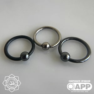 May include: Three different colored captive bead rings. The rings are made of metal and have a black, silver, and gunmetal finish. The rings are all the same size and have a small bead in the center.
