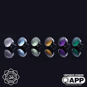Puede incluir: Seis tapas de vidrio de diferentes colores para joyería corporal. Las tapas son redondas y tienen un acabado liso y brillante. Los colores son blanco, azul, verde, amarillo, morado y verde.