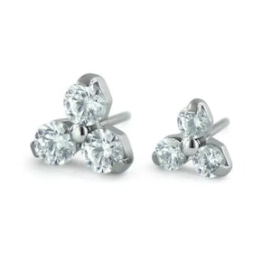 May include: Two silver body jewelry pieces with three clear gemstones each, shaped like a clover.