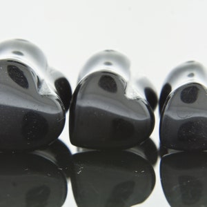 May include: Three black heart-shaped stone plugs of varying sizes.