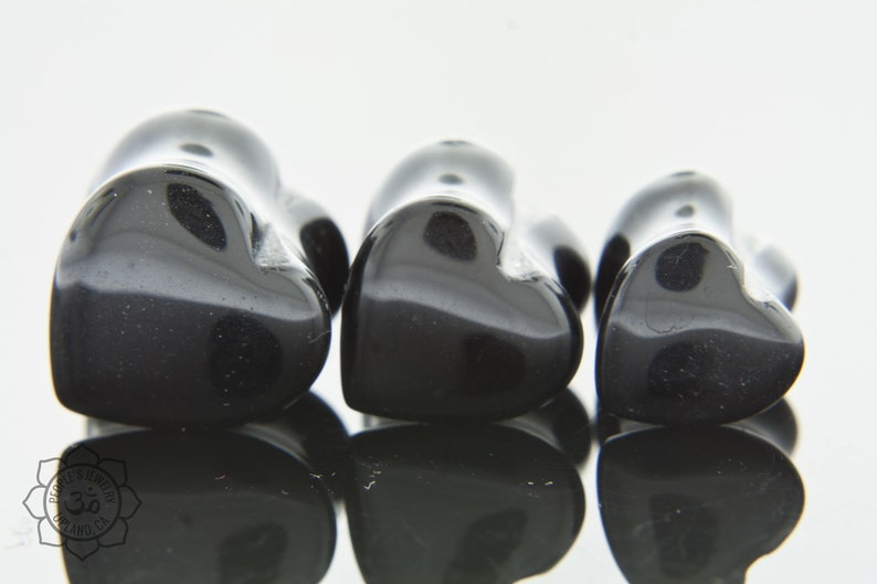 May include: Three black heart-shaped stone plugs of varying sizes.