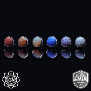 May include: Six different colored opal gemstone jewelry pieces, each with a silver setting. The gemstones are a mix of blue, purple, orange, and white. The image also includes a logo for People's Jewelry, a company based in California, USA.