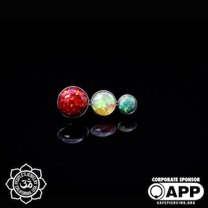 May include: Three round opalite gems in red, green, and white colors are attached to a silver bar. The gems are set in a bezel setting.