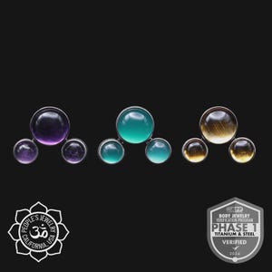 May include: Three sets of body jewelry with different colored gemstones. The first set has purple amethyst stones, the second has teal stones, and the third has tiger's eye stones. The jewelry is set in silver metal. The background is black.
