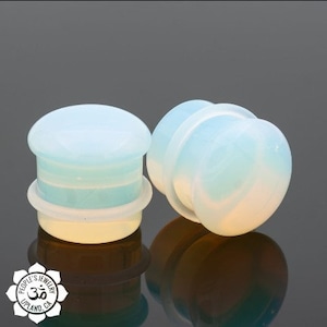 May include: Two pairs of white opal ear gauges. The gauges are made of a smooth, white opal material and have a slightly iridescent finish. The gauges are a popular choice for body jewelry and are available in a variety of sizes.