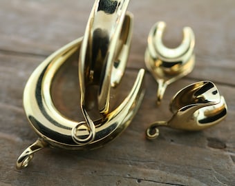 May include: Three gold-toned metal clasps for jewelry making. The clasps are in the shape of a crescent moon, a hook, and a loop.