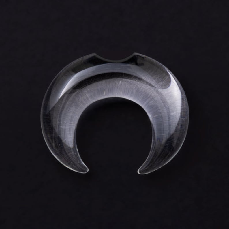 May include: Clear crescent moon shaped glass plug for stretched ears.