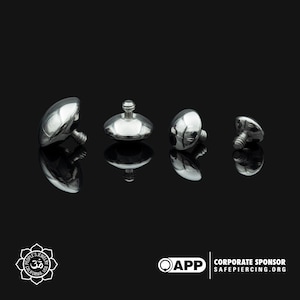 May include: Four silver-toned, dome-shaped, threaded body jewelry pieces with a flat top. The jewelry is arranged in a row on a black surface.