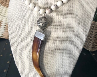 Collier long en perles de howlite et pendentif défense en acrylique