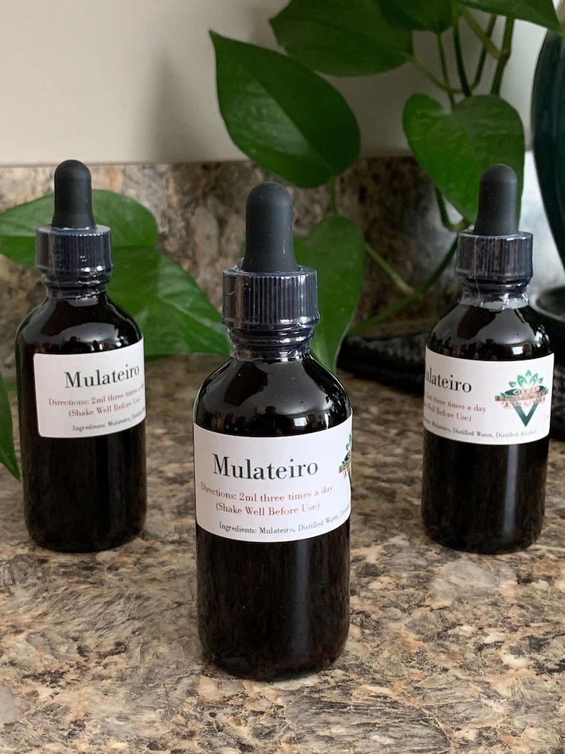 May include: Three dark brown glass bottles with dropper tops and white labels. The labels read "Mulateiro" and include directions for use. The bottles are sitting on a brown countertop.