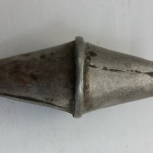 May include: A silver metal bead with a textured surface and a decorative band around the top.