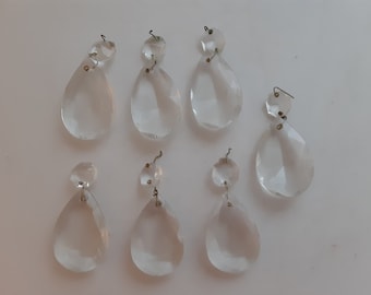 Puede incluir: Ocho colgantes de cristal de vidrio transparente con lazos de metal plateado. Las lágrimas son facetadas y tienen un ligero brillo.