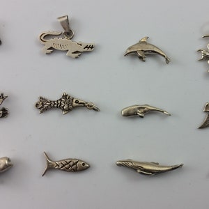 May include: A collection of 10 silver charm pendants featuring various sea creatures, including a dolphin, whale, fish, and seahorse. The charms are perfect for adding a touch of whimsy to jewellery.