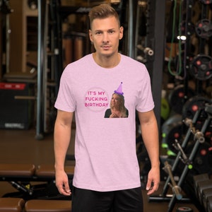 Könnte beinhalten: Rosa melierter T-Shirt mit einem rosa Kreis-Motiv, das eine Frau mit einer lilafarbenen Partymütze und dem Text "It's my fucking birthday" zeigt.