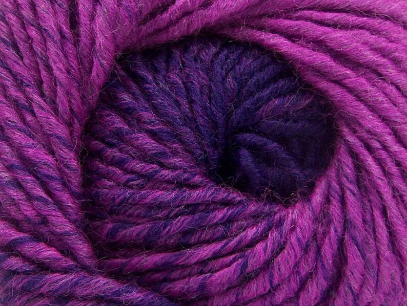 May include: A close-up of a ball of purple and dark purple yarn. The yarn is soft and fluffy, and it is perfect for knitting or crocheting.