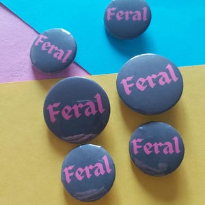 以下が含まれることがあります： ピンクの文字で「フェラル」と書かれた灰色の丸いボタンが5つあります。