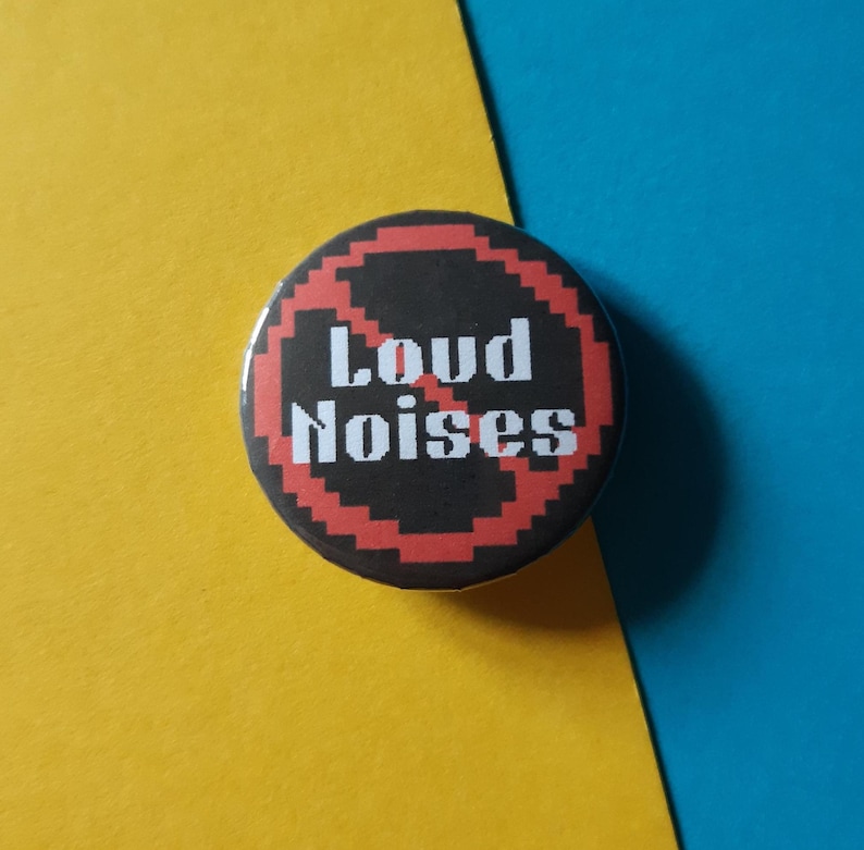 May include: A black and red button with a diagonal red line through it and the text "Loud Noises" in white.