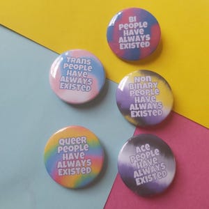 May include: Five round tie-dye buttons with the text "Trans People Have Always Existed", "Queer People Have Always Existed", "Bi People Have Always Existed", "Non Binary People Have Always Existed", and "Ace People Have Always Existed".