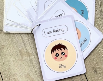 May include: A set of flashcards with different facial expressions and the text "I am feeling..." on each card. The card shown features a cartoon illustration of a person with a shy expression and the word "Shy" below the illustration.
