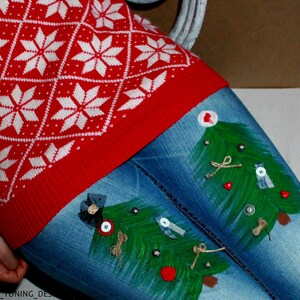 May include: A red and white sweater with a diamond and snowflake pattern paired with blue denim jeans featuring two hand-painted green Christmas trees decorated with small buttons, bows, and twine accents on the front of the legs.