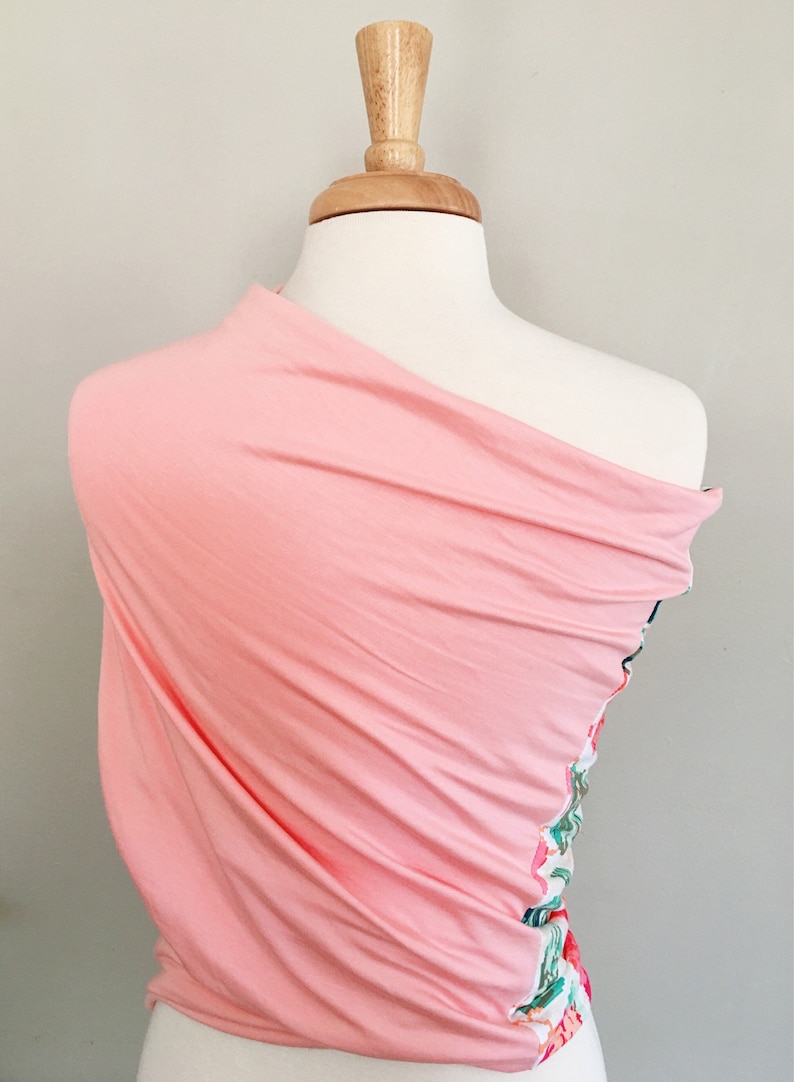 May include: A pink fabric wrap with a floral pattern on one side. The wrap is draped over a white mannequin.
