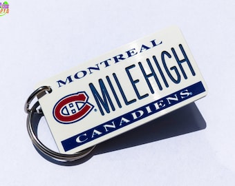 May include: White keychain with a blue and red Montreal Canadiens logo, the text "Montreal Mile High Canadiens" and a silver key ring.