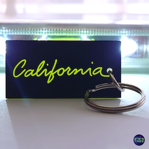 May include: A black keychain with a yellow "California" inscription and a silver key ring.
