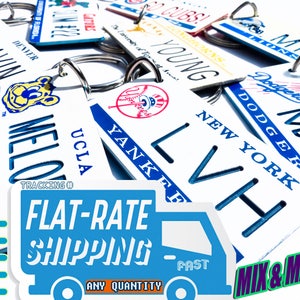 May include: A collection of personalized license plate keychains with various team logos and names, including Bruins, Dodgers, Yankees, Cubs, and more. The keychains are white with blue lettering and logos. The keychains are displayed on a blue and white background with the text "FLAT-RATE SHIPPING" and "MIX & MATCH!"