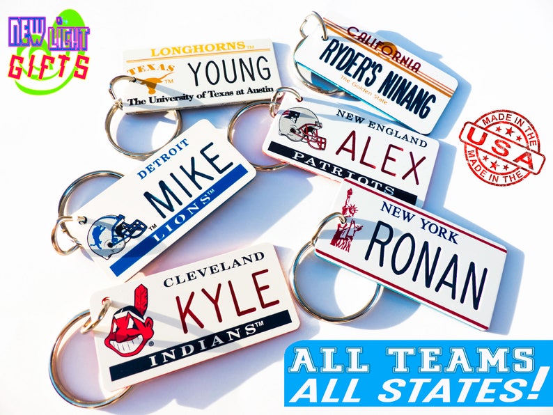 May include: A collection of personalized keychains featuring different sports team logos and state names. The keychains are white with colorful accents and feature names like "Mike", "Alex", "Ronan", and "Kyle". The keychains are made in the USA.