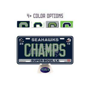 May include: A navy blue license plate with the text "SEAHAWKS CHAMPS SUPER BOWL LX". The plate has green and white accents and the number 29 and 13. The image also shows 4+ color options.