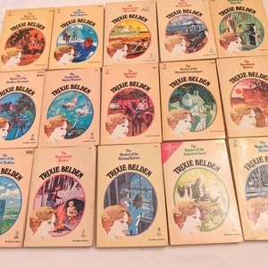 May include: A collection of 12 vintage paperback books featuring the character Trixie Belden. The books have colorful covers with illustrations of a young girl and various scenes. The titles of the books include "The Mystery of the Hidden Treasure", "The Secret of the Crooked Cat", "The Mystery of the Phantom  Grasshopper", "The Mystery of the Missing Heiress", and "The Mystery of the Uninvited Guest".