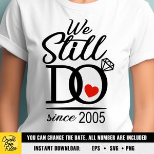 Könnte beinhalten: Weißes T-Shirt mit schwarzem Grafikdesign. Das Design enthält die Worte "We Still Do" über dem Wort "DO", das als Ehering mit rotem Herz gestaltet ist. Der Text "since 2005" steht darunter. Das Shirt enthält auch den Text "YOU CAN CHANGE THE DATE, ALL NUMBER ARE INCLUDED".