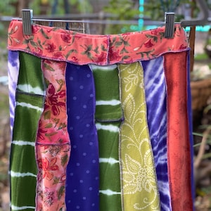 May include: A colorful patchwork skirt with a variety of floral and geometric patterns. The skirt is made from different fabrics sewn together, creating a unique and eclectic look.
