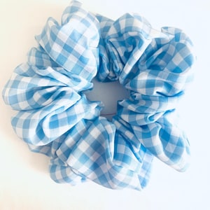 May include: A blue and white gingham scrunchie hair tie. The scrunchie is made of soft fabric and is perfect for adding a touch of style to any outfit.