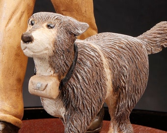 Best friends walk together. Hand carved and painted wood figure shows a man and his dog walking down a country road.