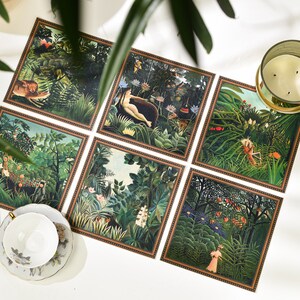 Puede incluir: Un conjunto de seis impresiones art&iacute;sticas cuadradas que representan escenas de la jungla con animales y figuras. Las impresiones tienen un borde marr&oacute;n y est&aacute;n dispuestas sobre una superficie blanca. Tambi&eacute;n se ven una taza de t&eacute; y una vela.