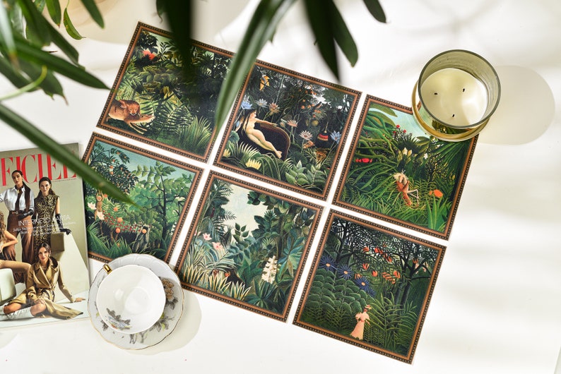 Puede incluir: Un conjunto de seis impresiones art&iacute;sticas cuadradas que representan escenas de la jungla con animales y figuras. Las impresiones tienen un borde marr&oacute;n y est&aacute;n dispuestas sobre una superficie blanca. Tambi&eacute;n se ven una taza de t&eacute; y una vela.