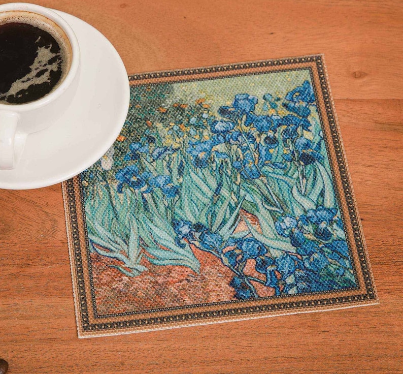 Puede incluir: Un posavasos cuadrado con una imagen enmarcada de una pintura de iris azules con hojas verdes. El posavasos tiene un fondo marr&oacute;n con un borde dorado.