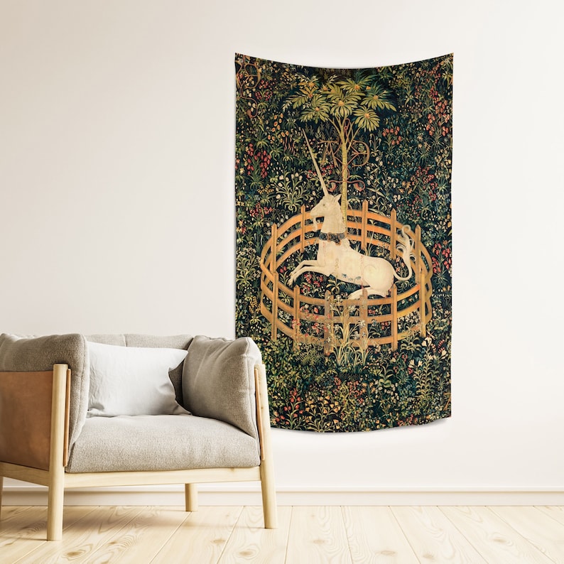 May include: A tapestry featuring a white unicorn trapped in a circular fence, surrounded by a lush green forest with flowers and foliage. The unicorn is depicted with a golden horn and a flowing mane.