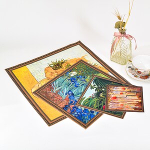May include: Three framed art prints with different floral and landscape designs. The largest print features a yellow sunflower, the middle print features blue irises, and the smallest print features a colorful landscape.