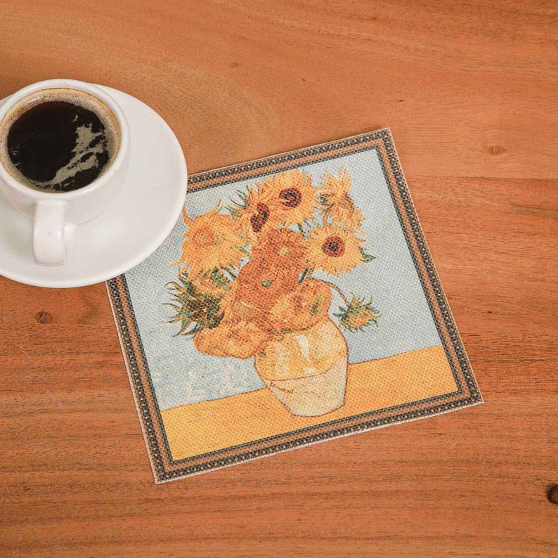 Puede incluir: Un posavasos con una reproducci&oacute;n de la pintura "Girasoles" de Vincent van Gogh. El posavasos es rectangular y tiene un borde marr&oacute;n.